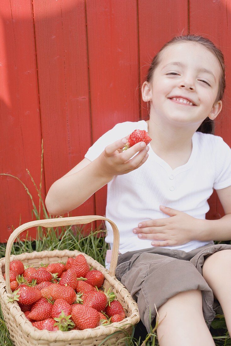 Little girl eating strawberries