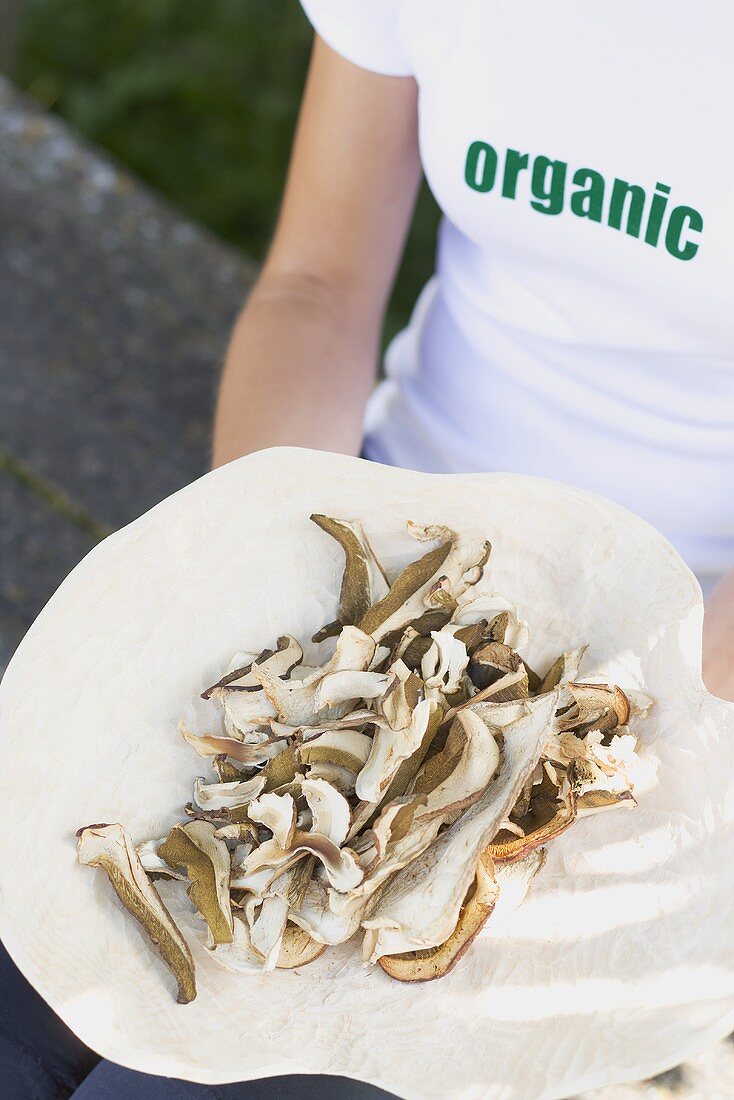 Woman holding dish of sliced mushrooms