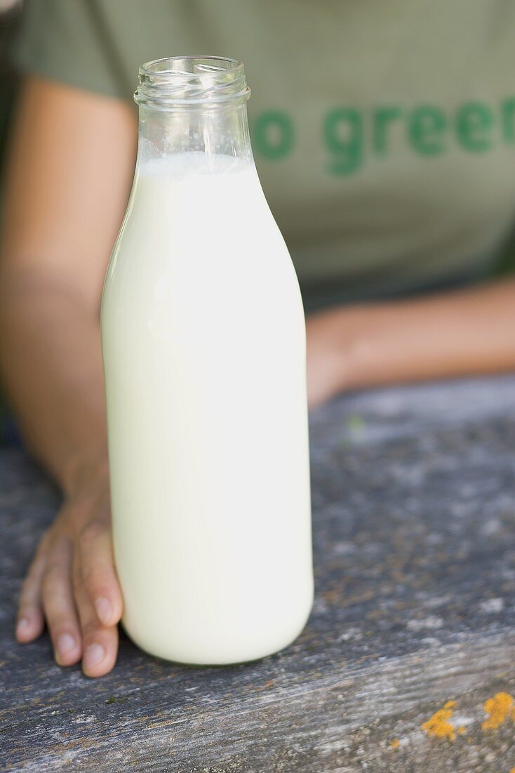 Frau hält Flasche Bio-Milch