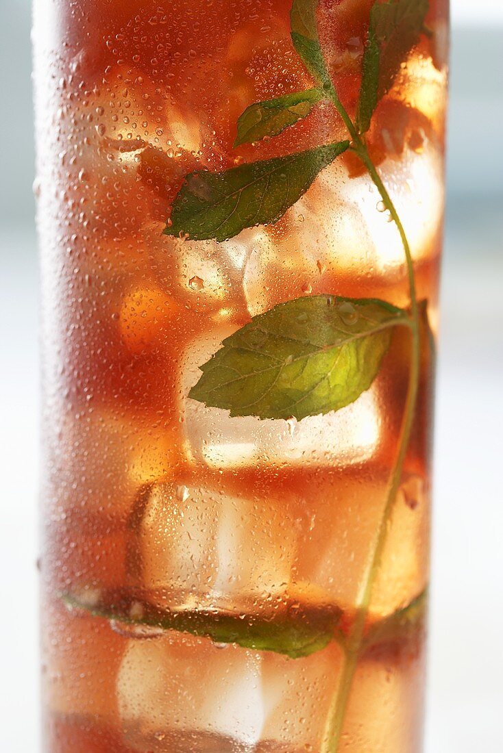 A glass of iced tea with mint