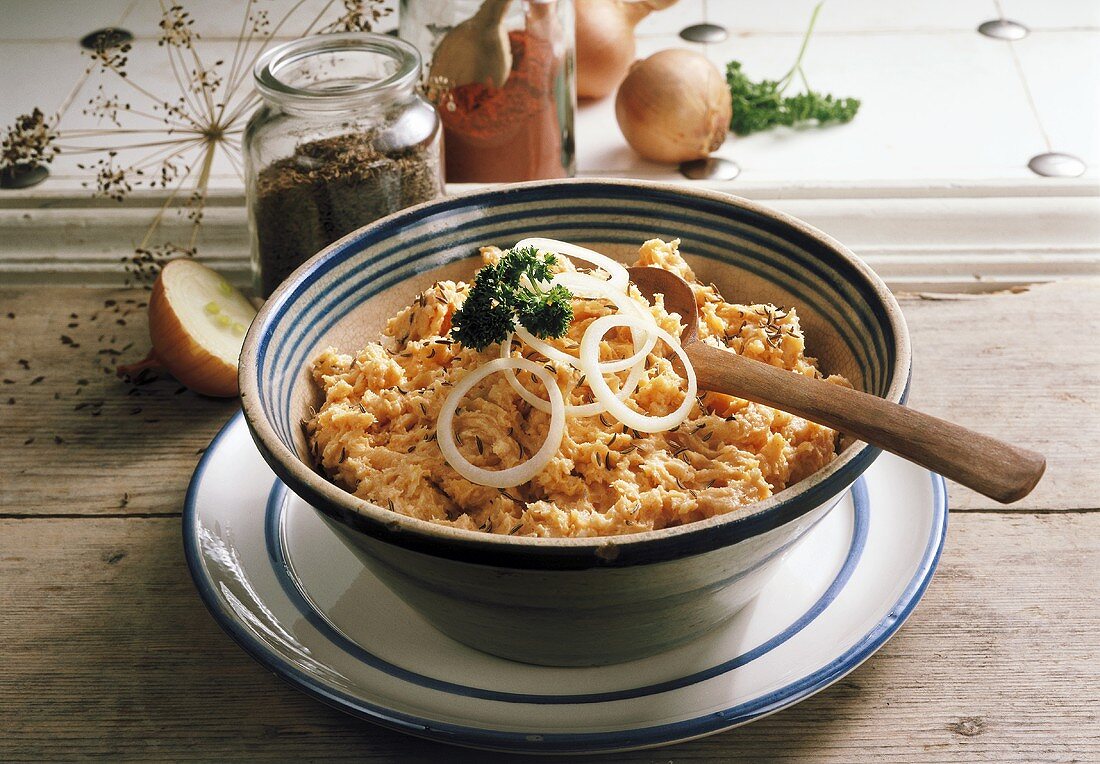 Obatzda (Bavarian cheese spread) in bowl with wooden spoon