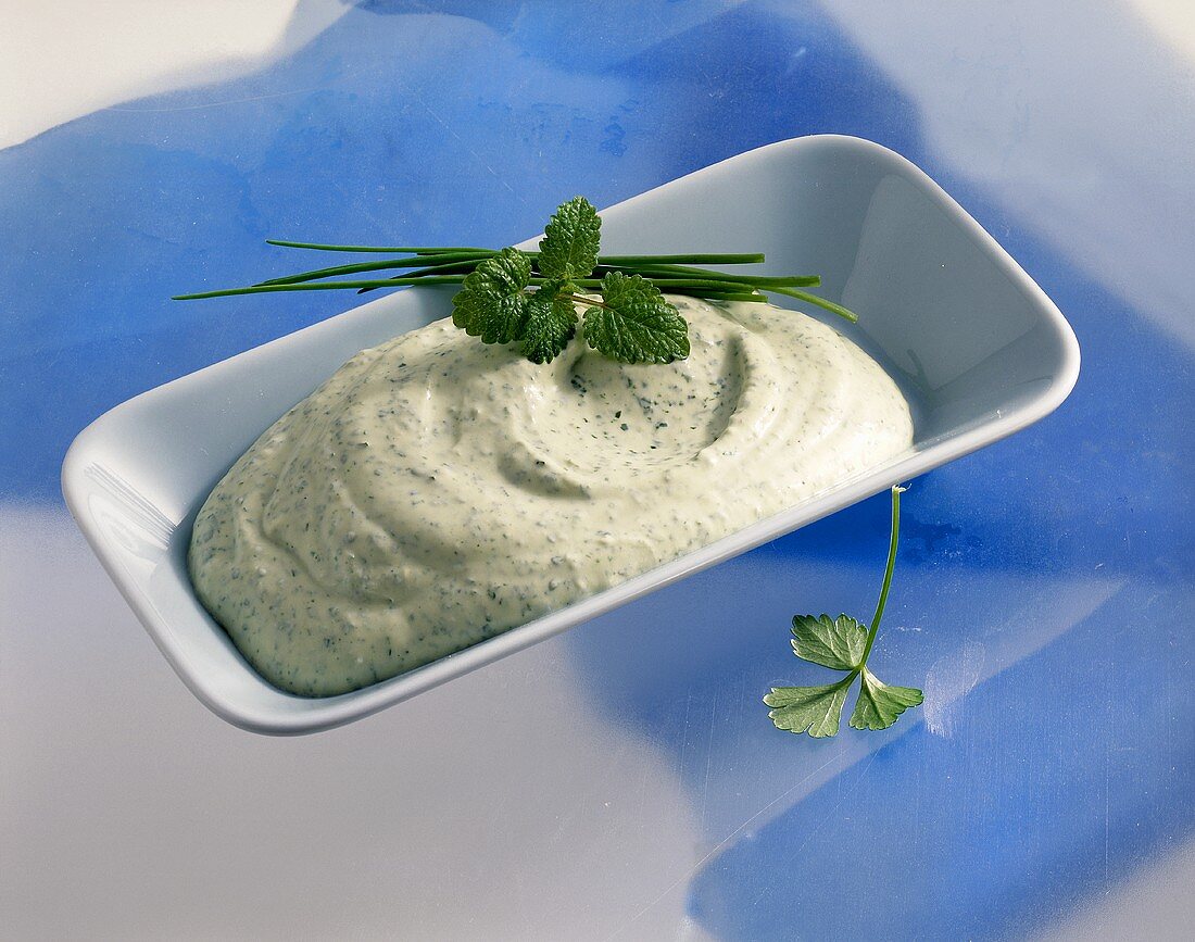 A dish of mascarpone salad dressing with herbs