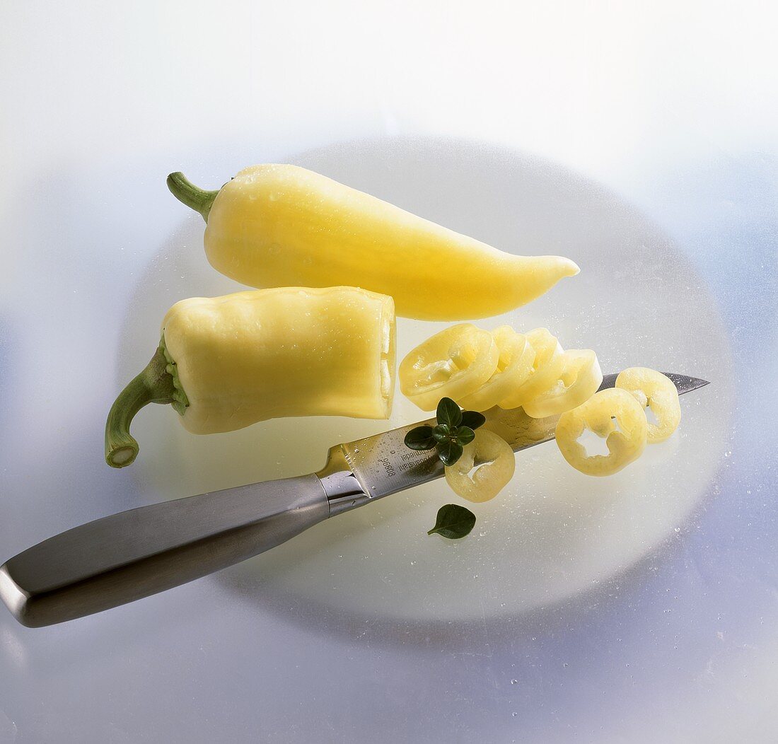 Gelbe Spitzpaprika, angeschnitten mit Küchenmesser