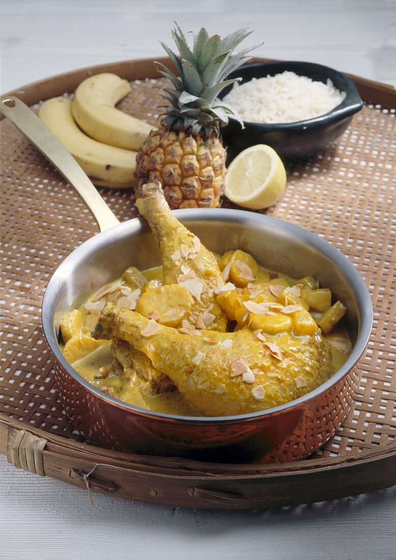 Chicken legs in curry sauce with banana, pineapple, almonds