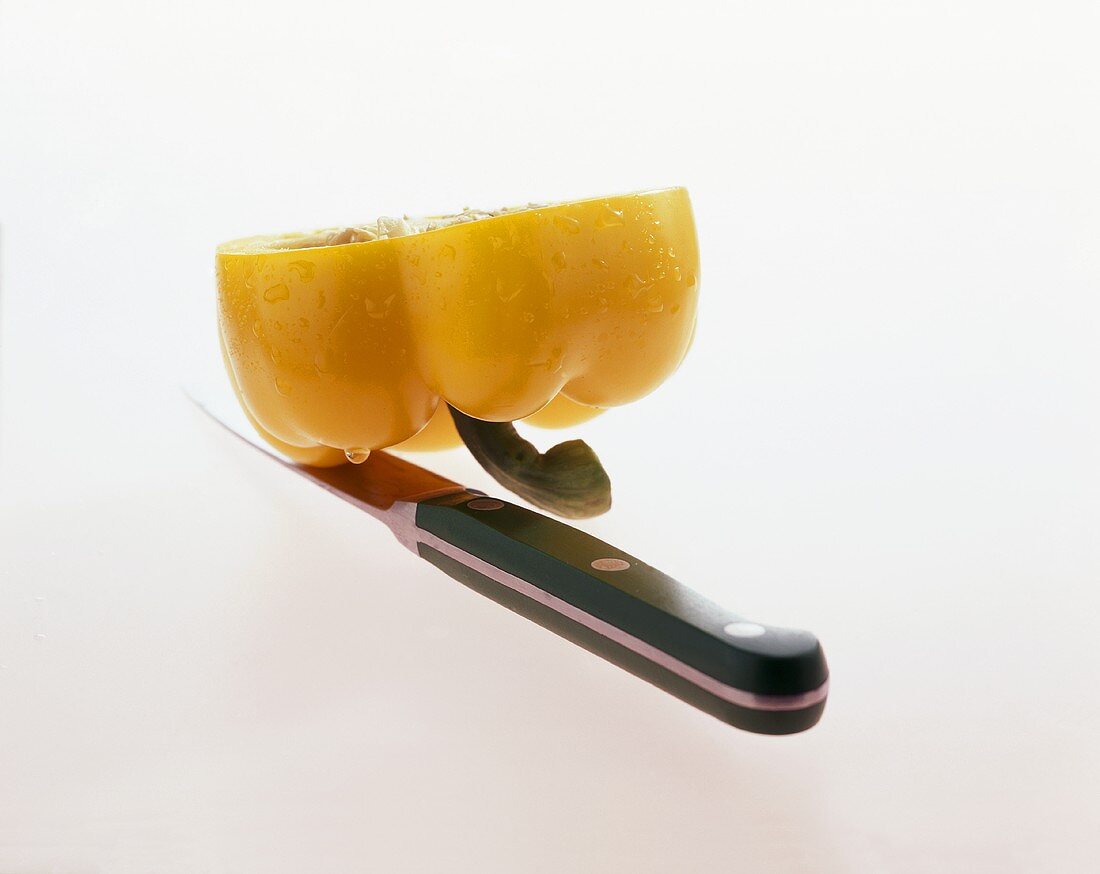 Halved yellow pepper with a knife