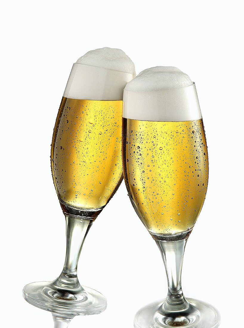 Two glasses of pils clinking together