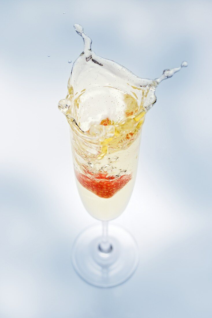A glass of sparkling wine with strawberry (splash)