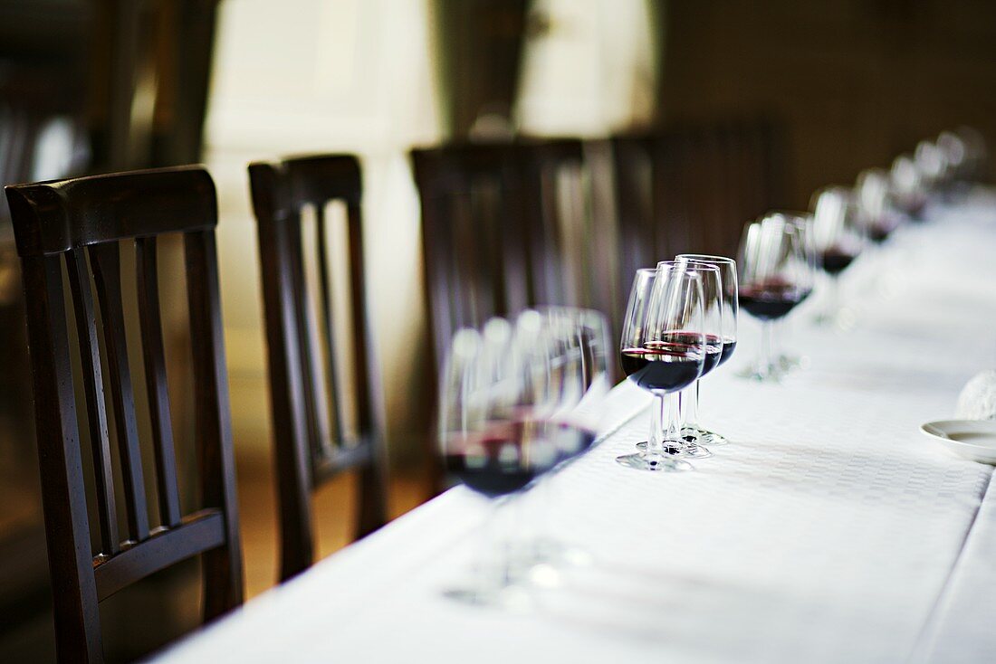 Weiß gedeckter Tisch mit Rotweingläsern