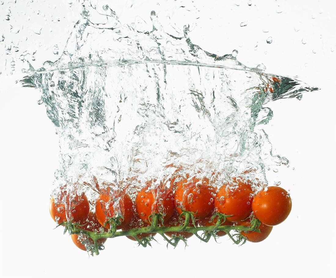 Cherry tomatoes falling into water