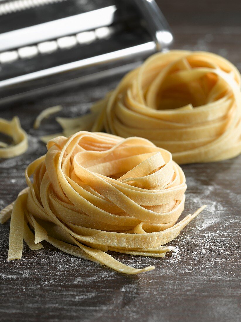 Home-made ribbon pasta in front of pasta maker