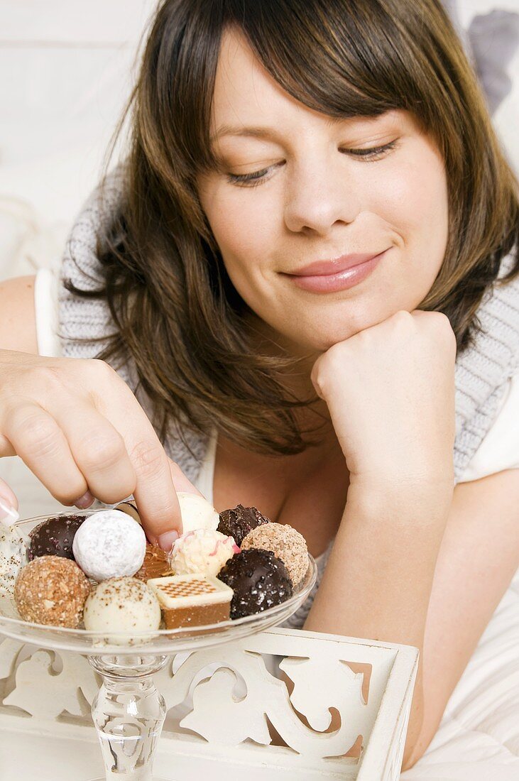 Young woman reaching for a chocolate