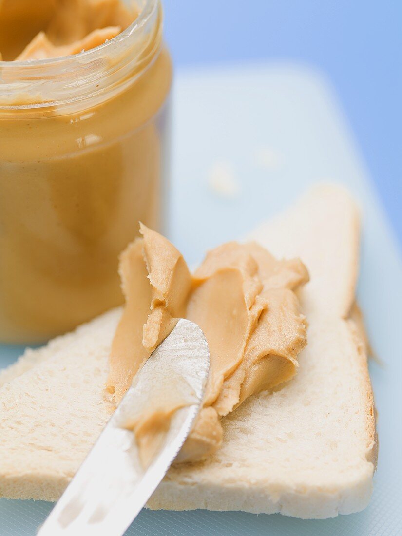 Erdnussbutter auf Weißbrot und im Glas