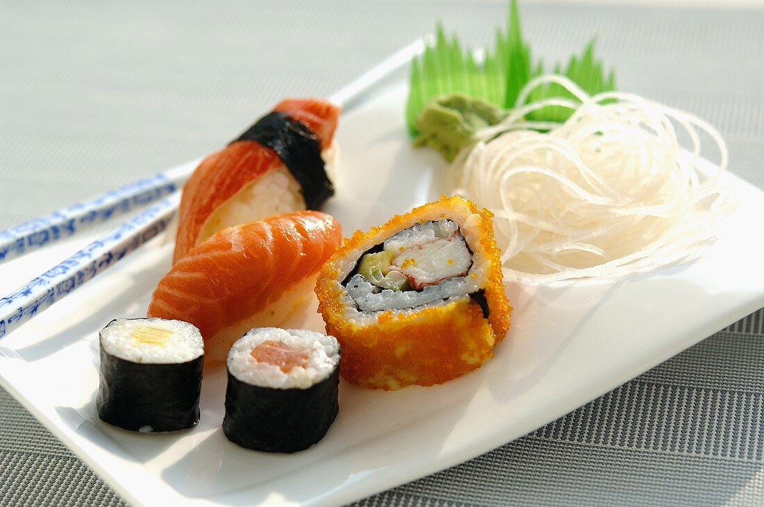 Verschiedene Sushi auf einem Teller mit Rettich