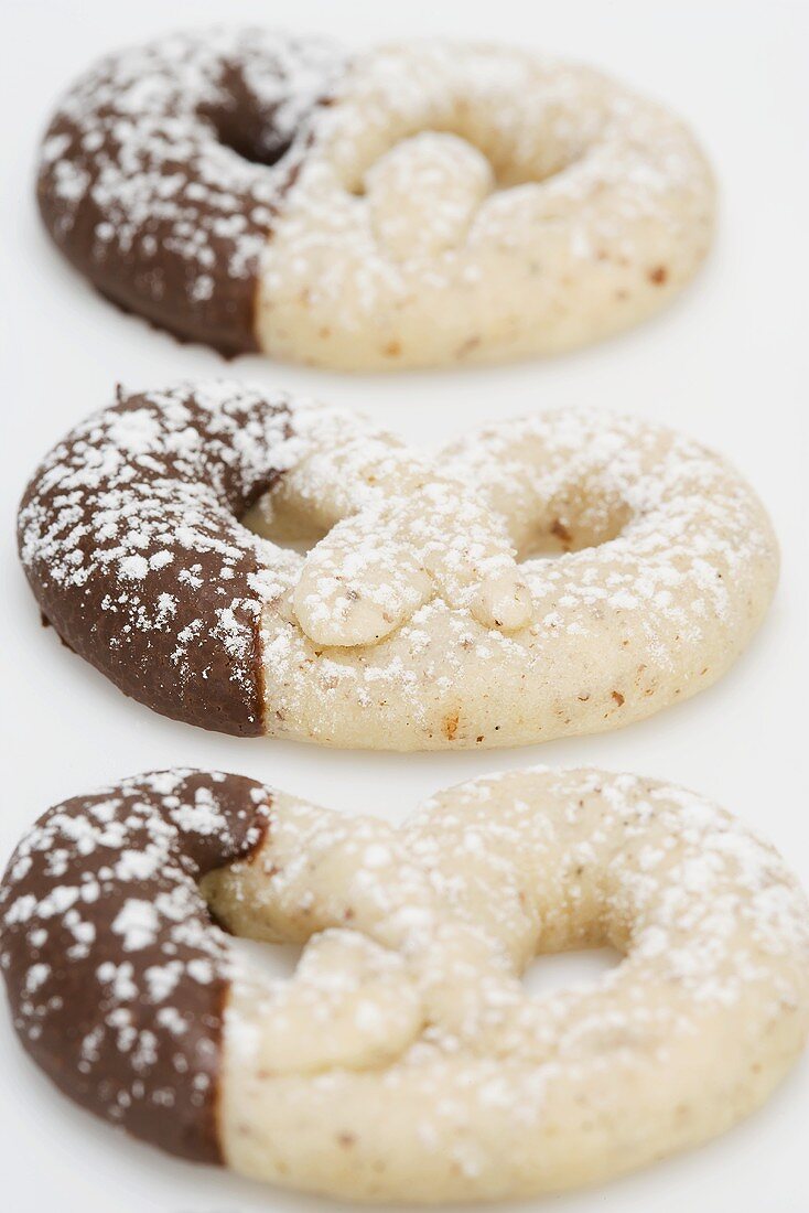 Chocolate-dipped hazelnut pretzels with icing sugar