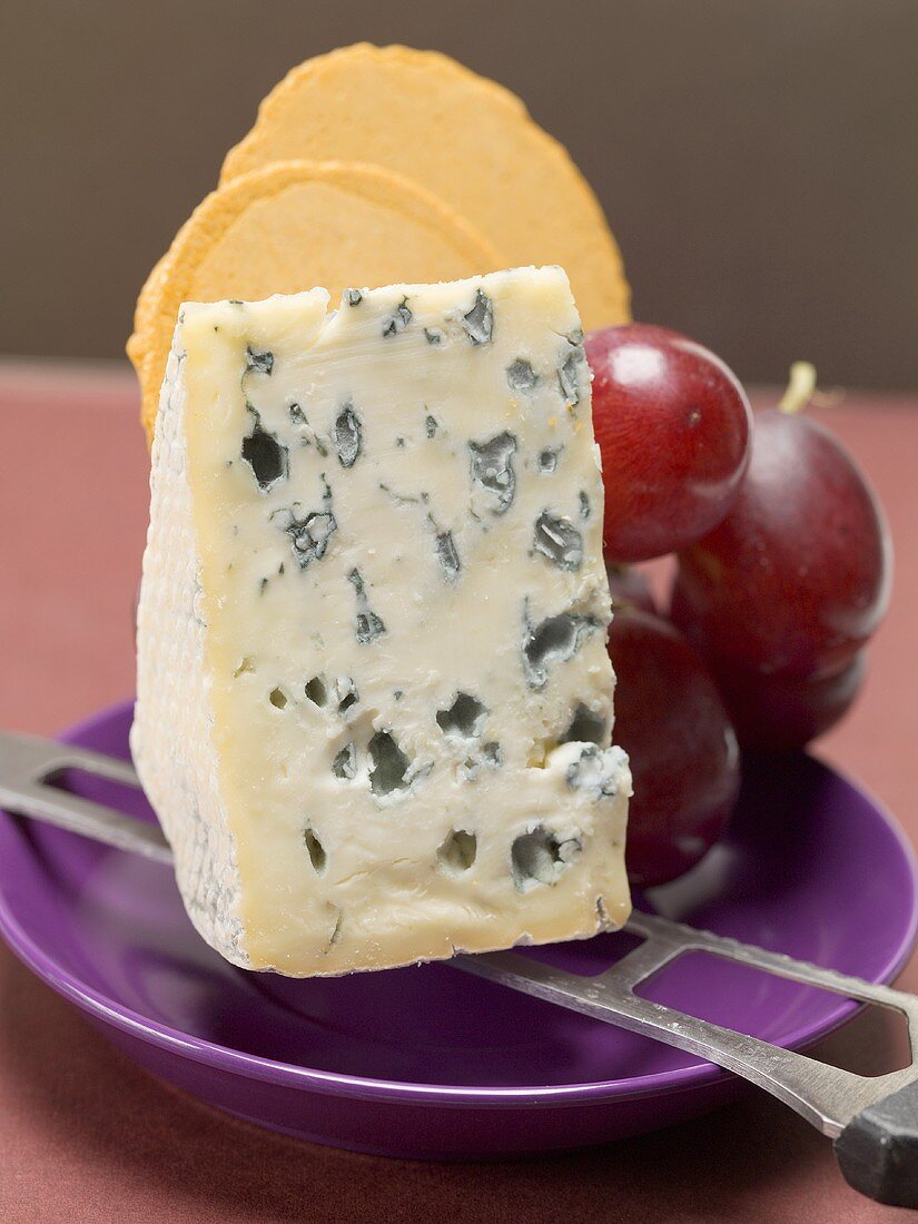 Stück Blauschimmelkäse, rote Trauben und Cracker