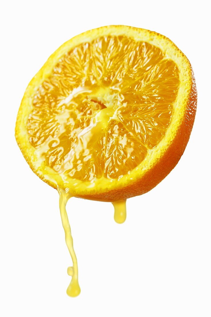 Half an orange dripping juice