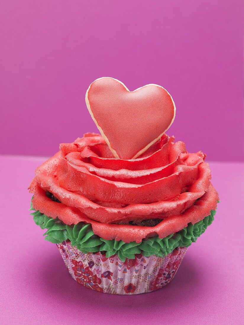 Cupcake with red marzipan rose and red pastry heart