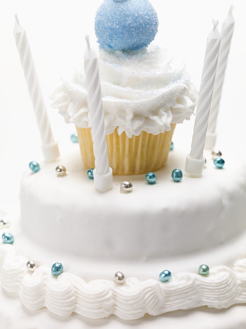 White birthday cake with dragées and candles