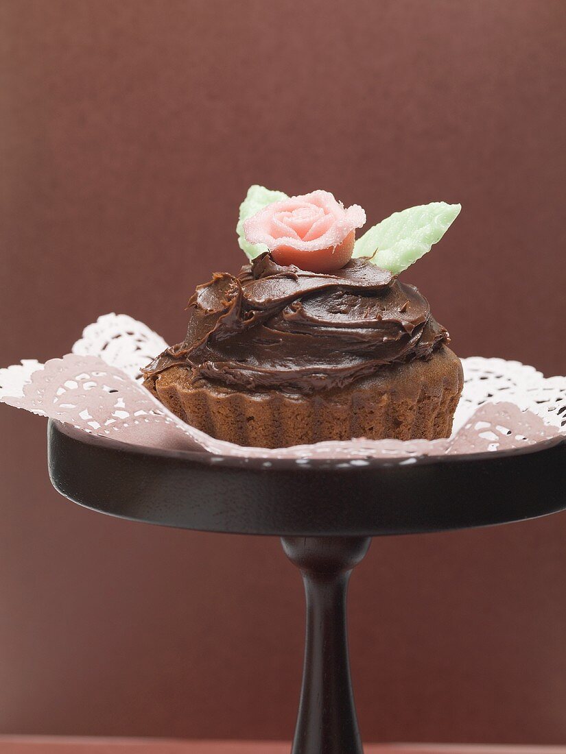 Chocolate cake with marzipan rose on cake stand