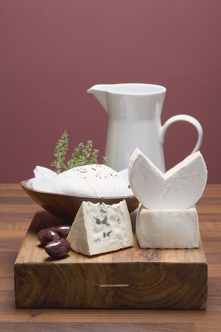 Cheese still life with olives and thyme