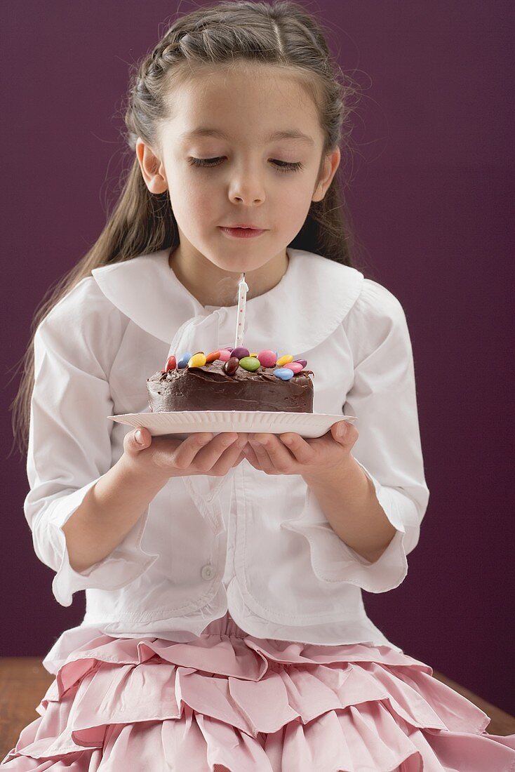 Little girl holding birthday cake