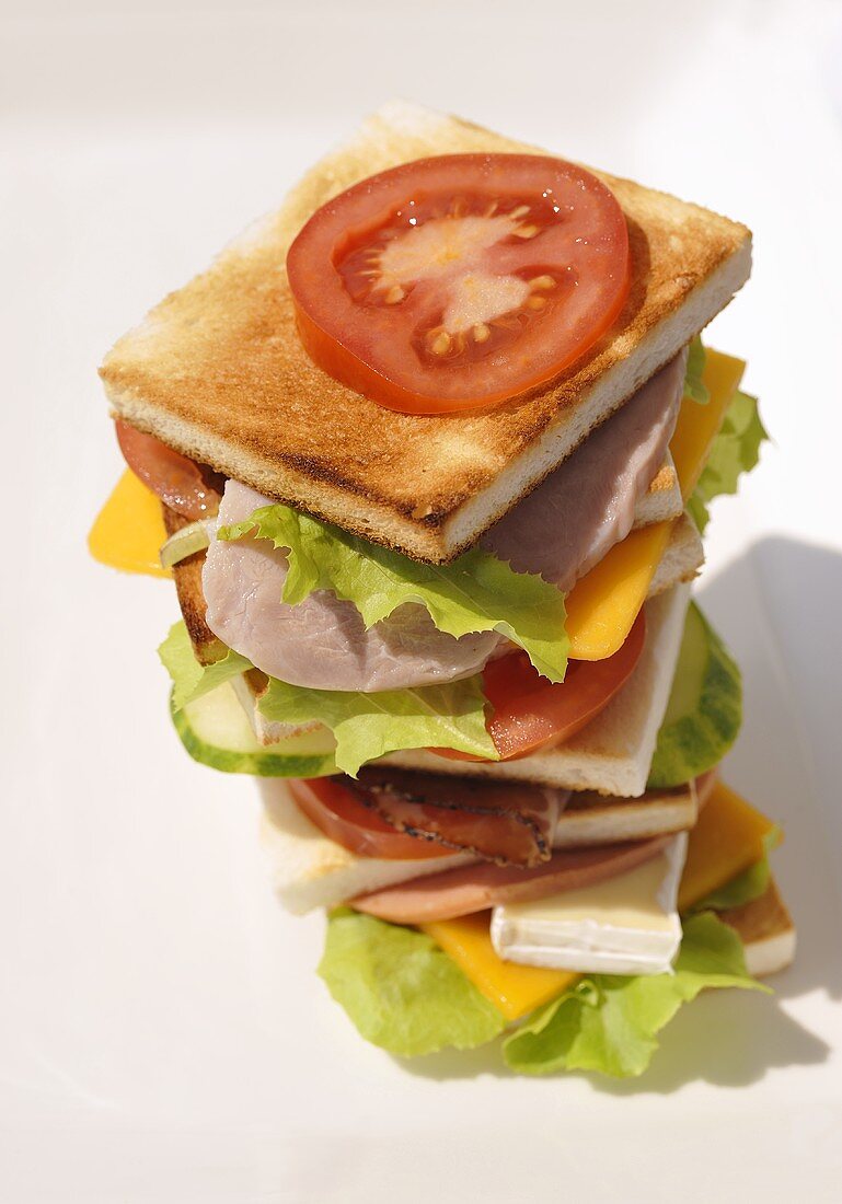 Tower of toast, ham, sausage, cheese, tomatoes and lettuce