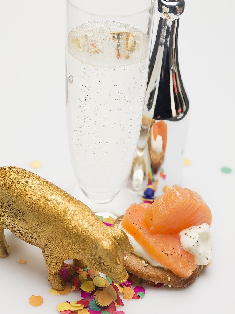 Glass of Prosecco, salmon appetiser, lucky pig & confetti