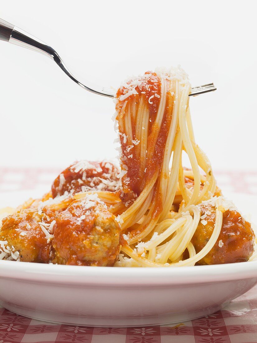 Spaghetti und Tomatensauce mit Fleischbällchen werden vermischt