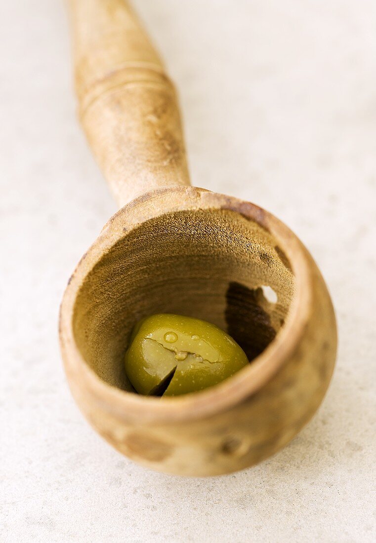 Olive in wooden ladle