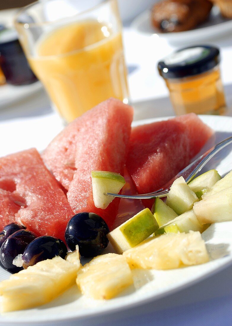 Plate of fruit, fruit juice and honey for breakfast