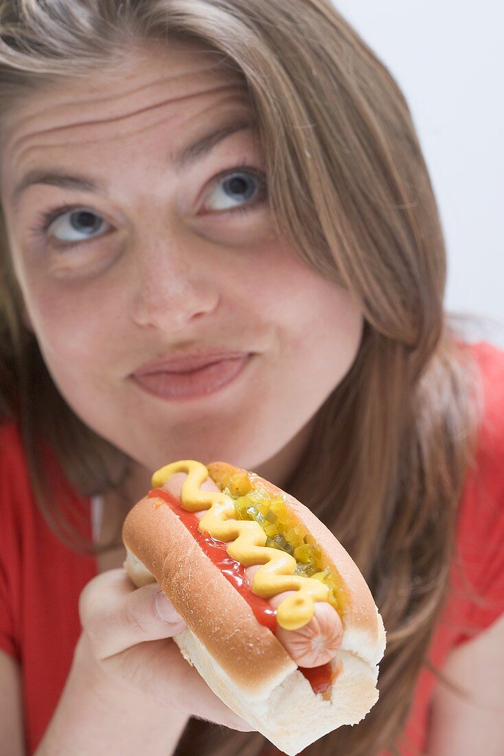 Pensive woman with hot dog