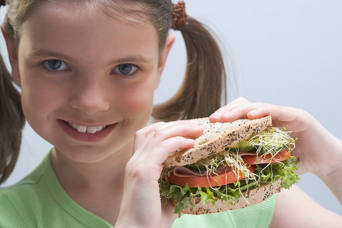Smiling girl holding a sandwich