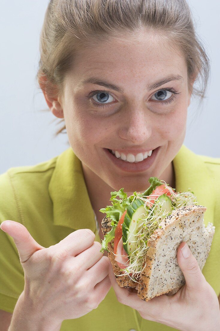 Smiling woman with sandwich