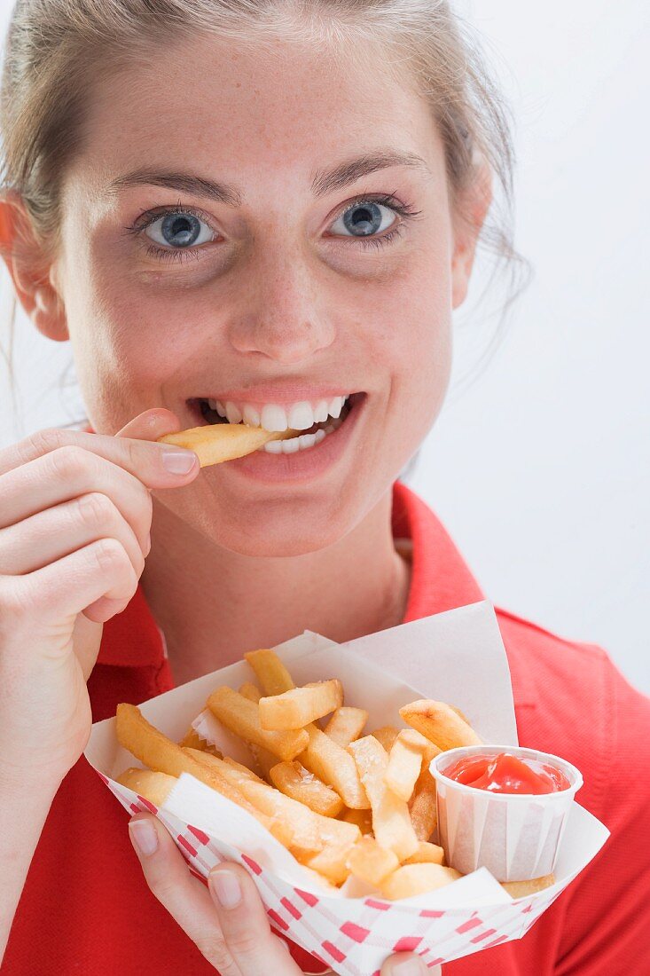 Junge Frau beim Pommes Frites essen