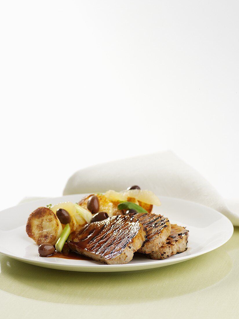 Grilled pork steaks with roast potatoes and olives
