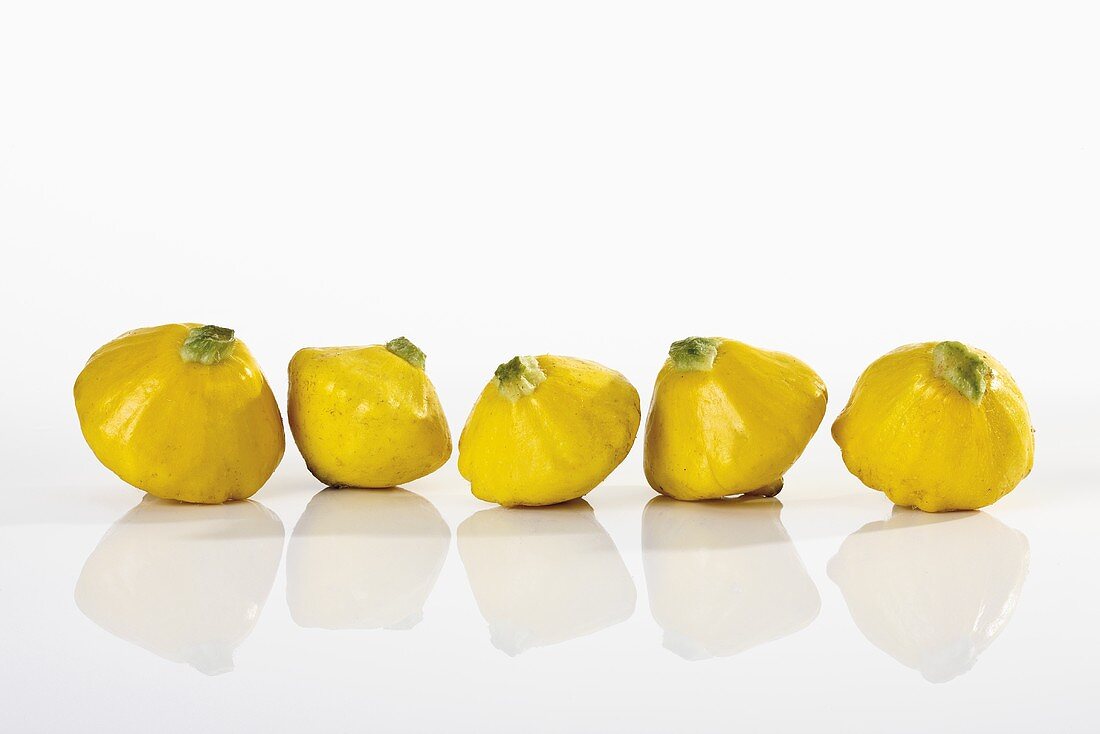 Yellow patty pan squashes in a row