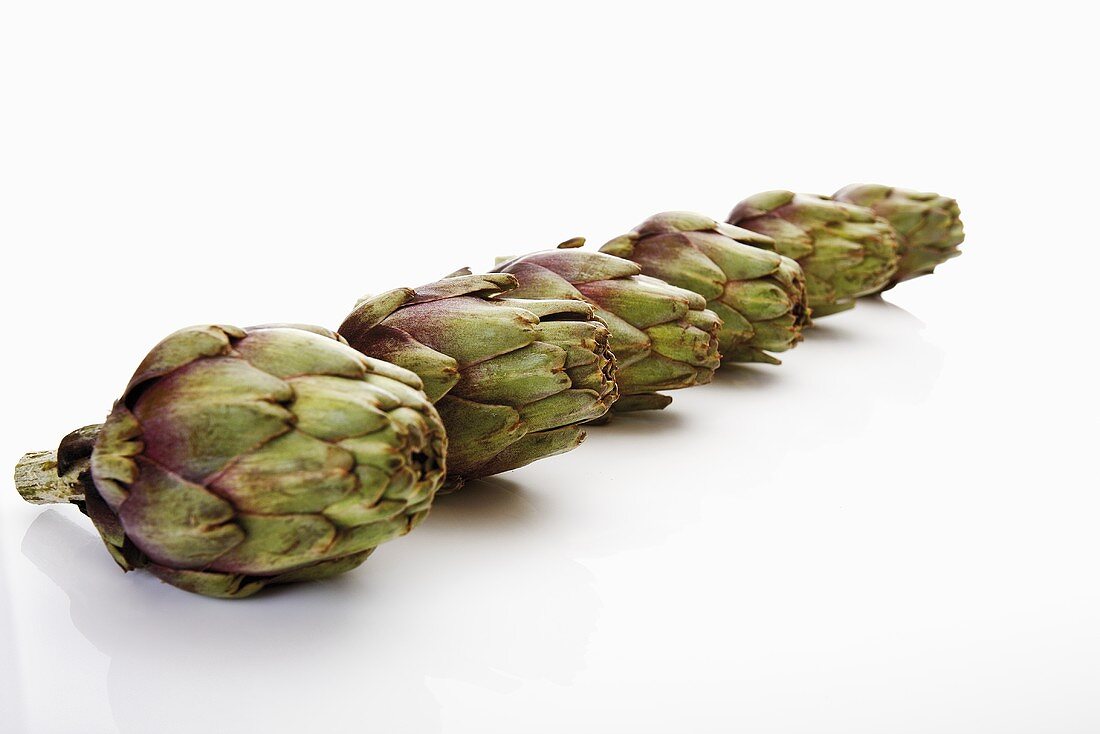 Several baby artichokes in a row