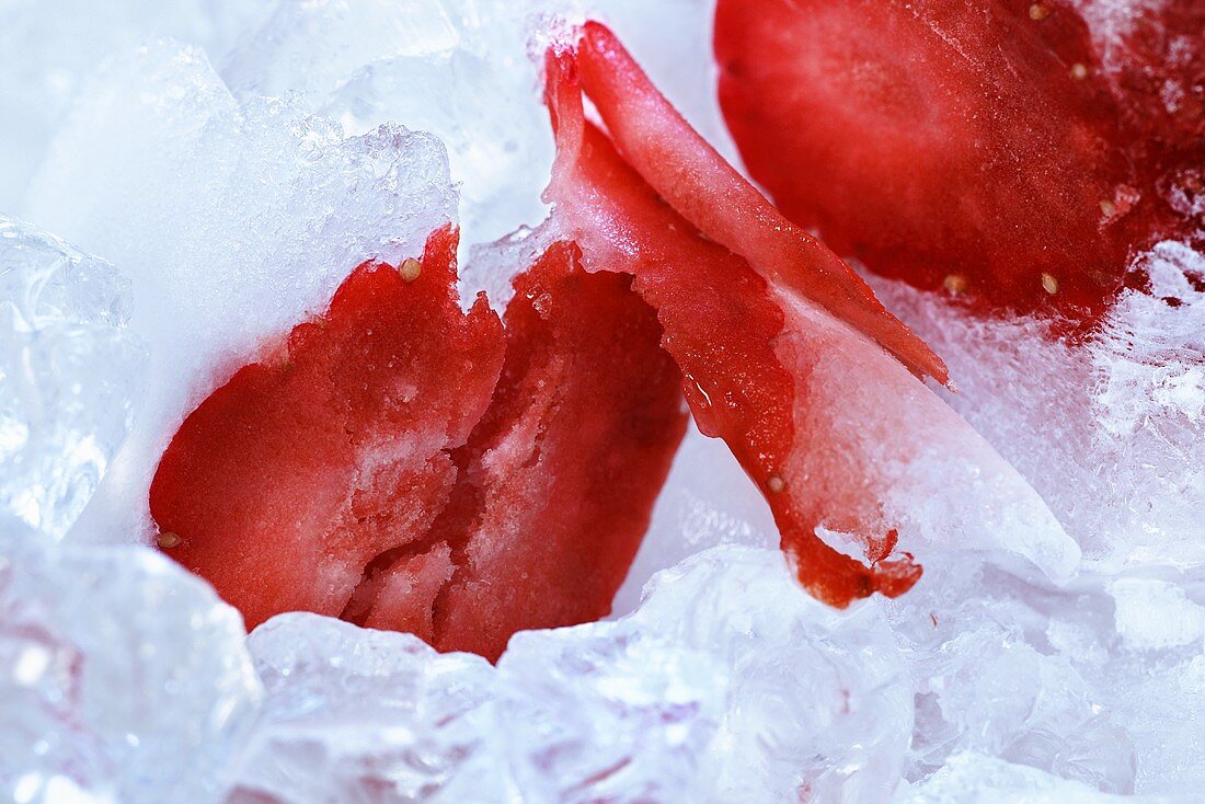 Sliced strawberry on ice (close-up)