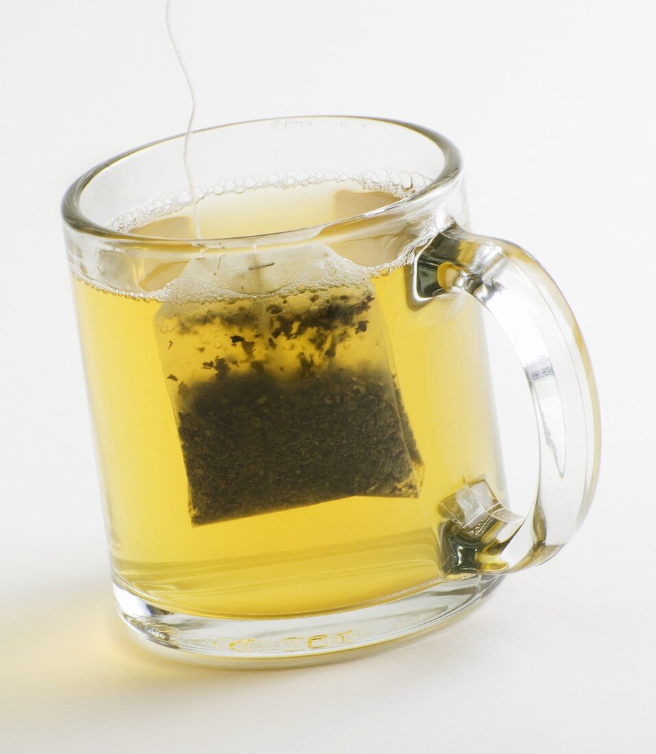 Grüner Tee mit Teebeutel in Glastasse