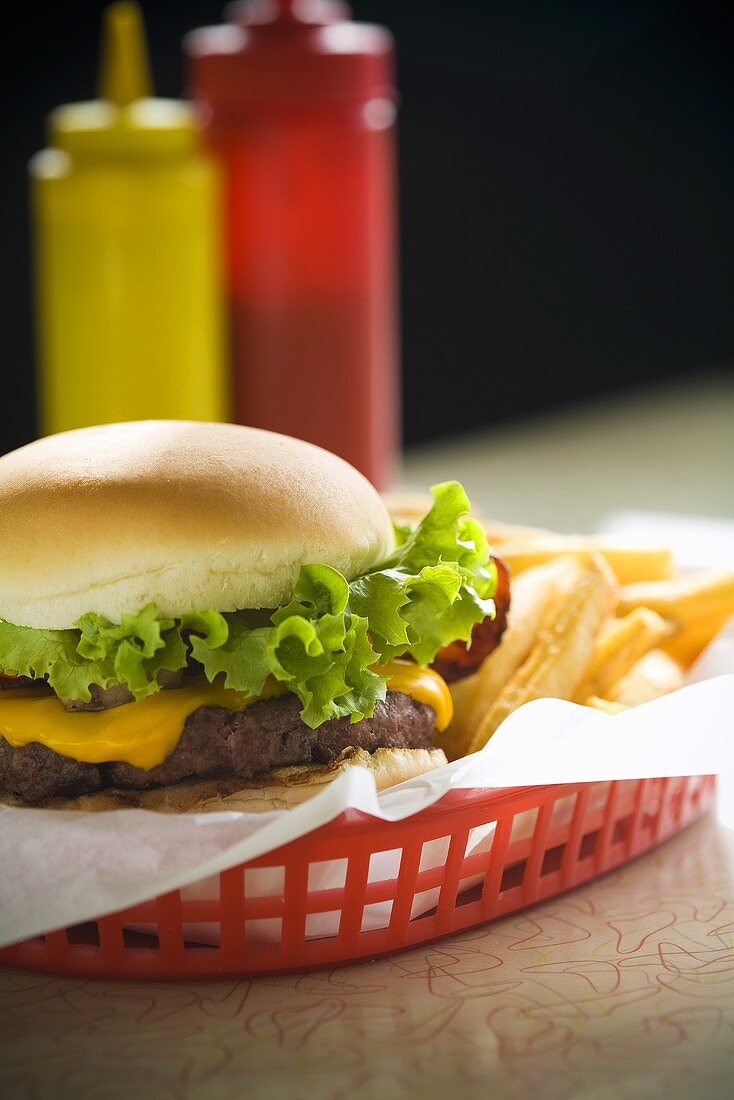 Cheeseburger and Fries in a Red Basket; Ketchup and Mustard