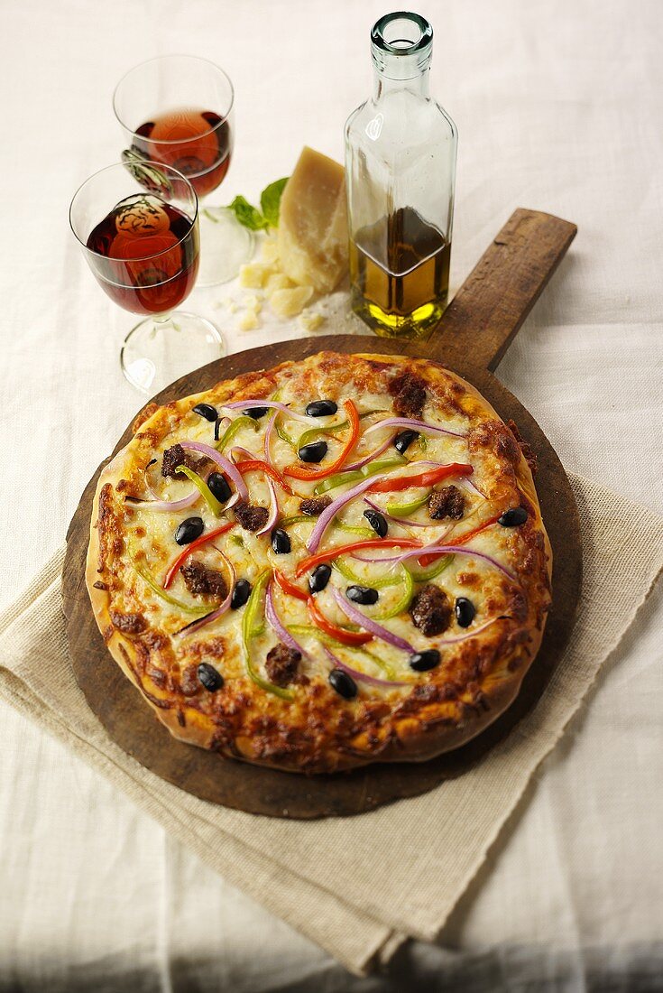 Sausage and Vegetable Pizza on Wooden Wheel with Wine