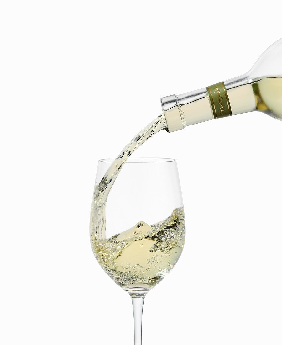 White Wine Pouring into a Glass From Bottle