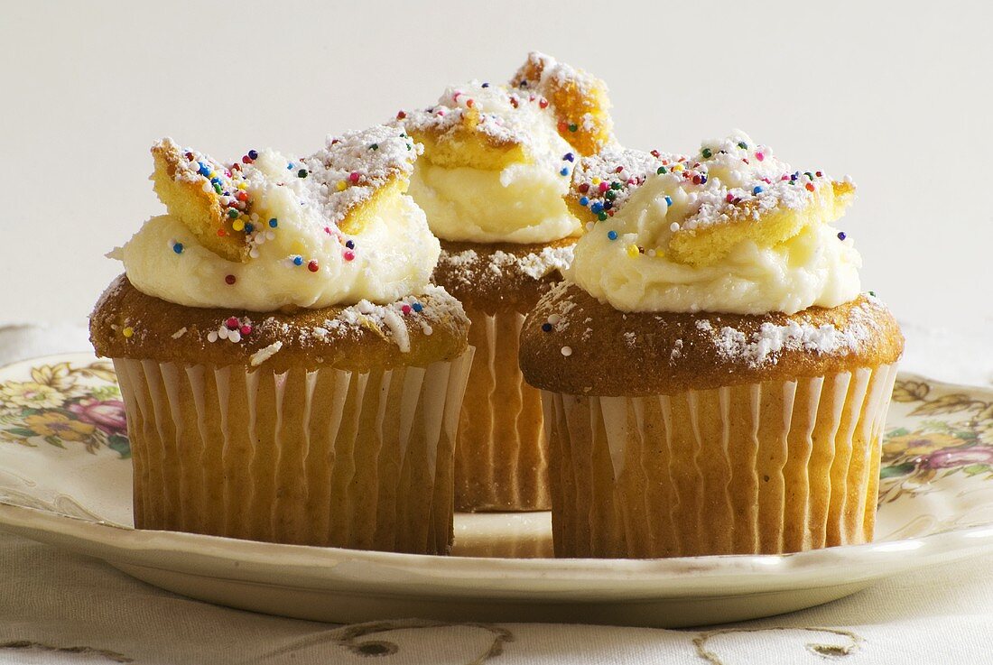 Drei Cupcakes mit bunten Zuckerstreuseln