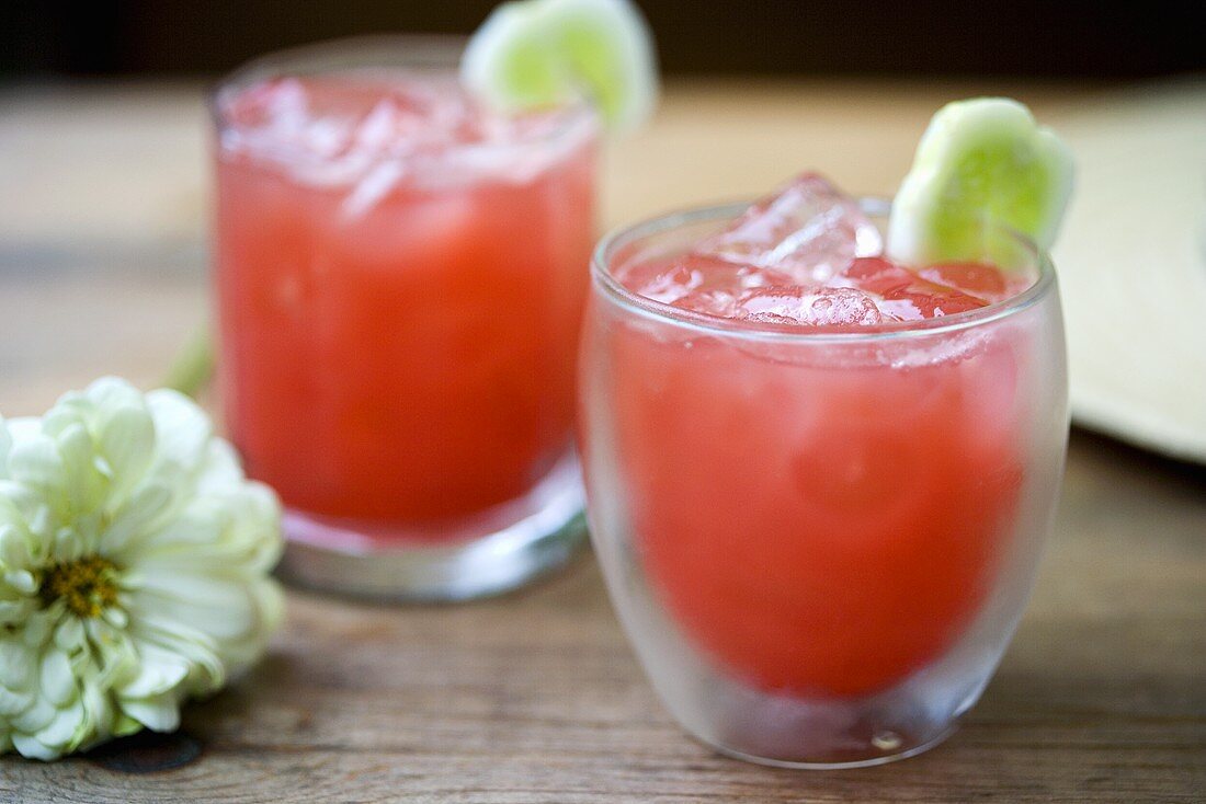 Two Watermelon Cocktails Over Ice with Cucumber Garnish