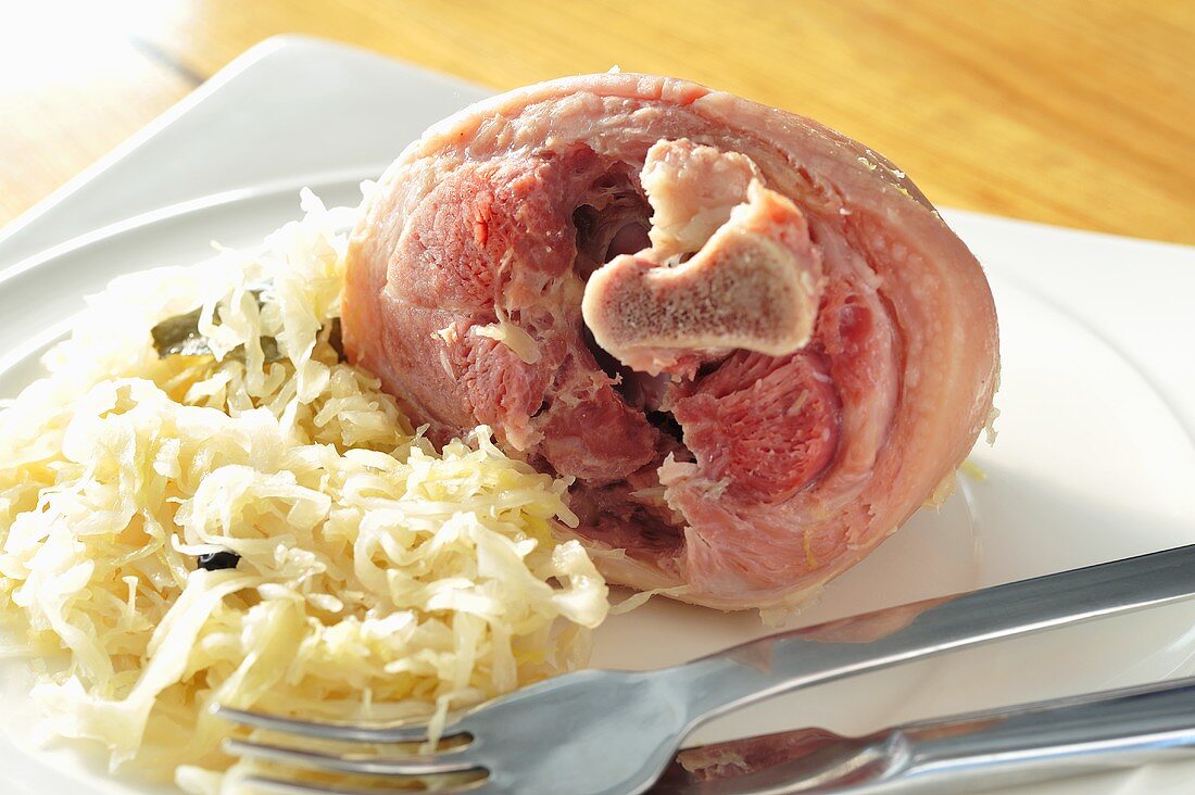 Cooked Eisbein (cured knuckle of pork) with sauerkraut