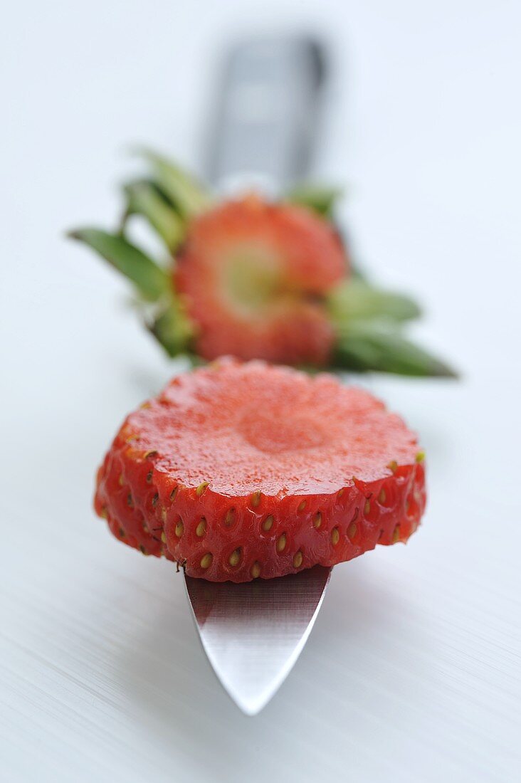 Slice of strawberry on knife point