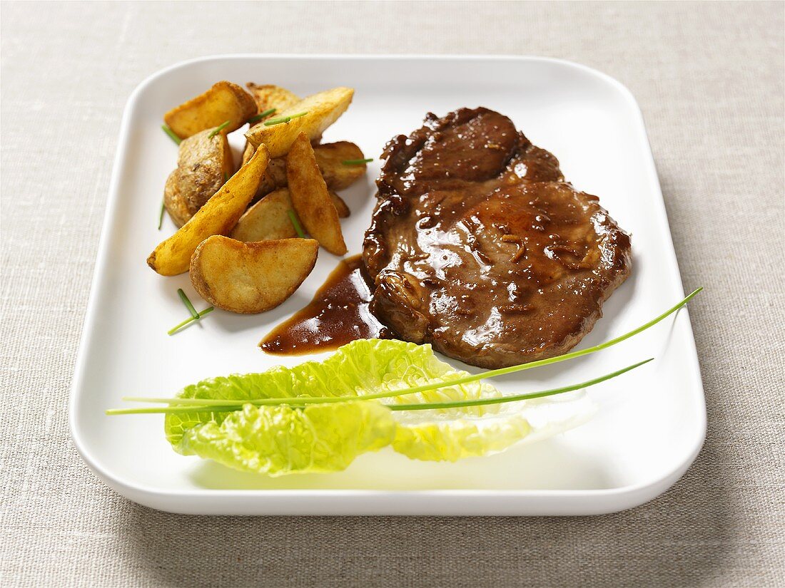 Pork steak with ginger sauce and potato wedges