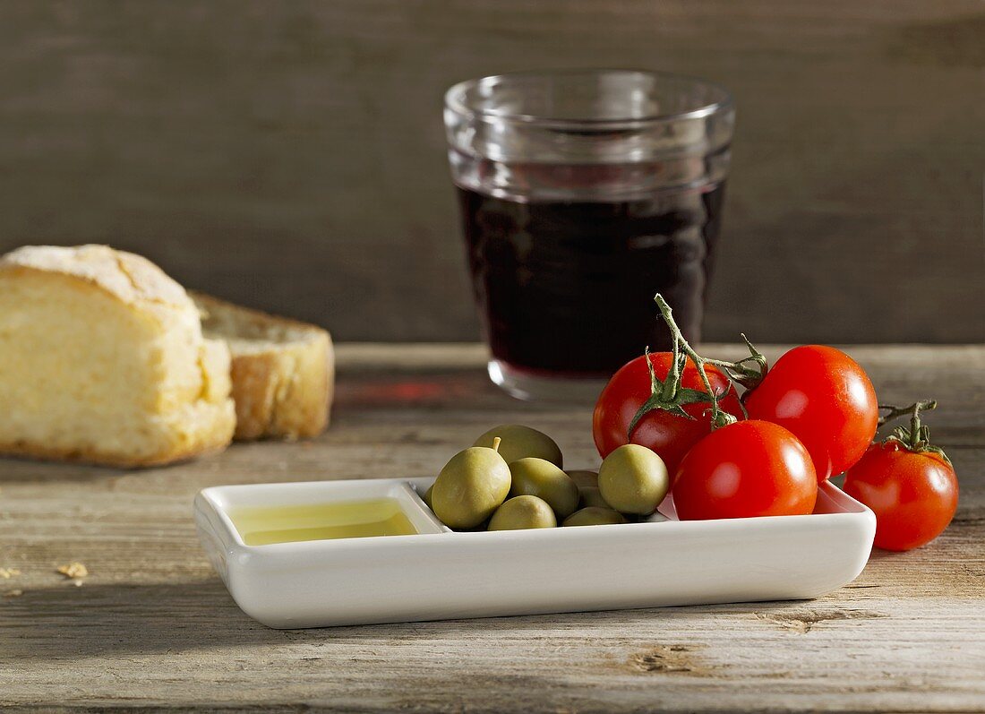 Stillleben mit Oliven, Tomaten, Brot, Rotwein (Italien)
