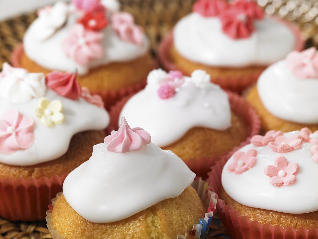 Mehrere Cupcakes mit Zuckerglasur und -deko