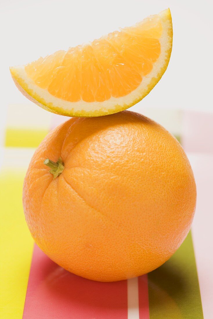 Orange and orange wedge on striped fabric background